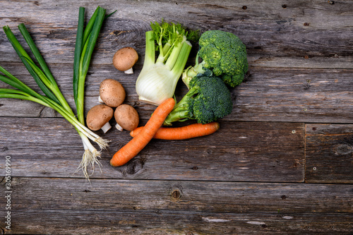  broccolion, spring onions, fennel, mushrooms and carrots wooden on board photo