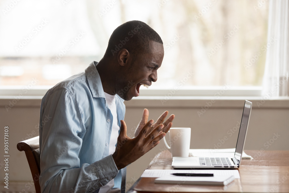 Furious biracial man scream having computer problems Furious biracial man scream having computer problems