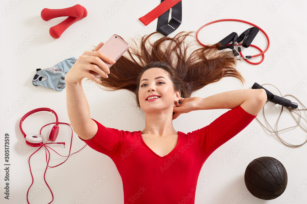 Sport woman smiling at camera of her moderm cell phone, making