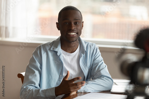 Motivated african American man talk on camera shooting video photo