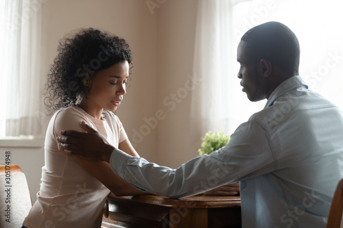 Loving african American husband comfort sad wife photo