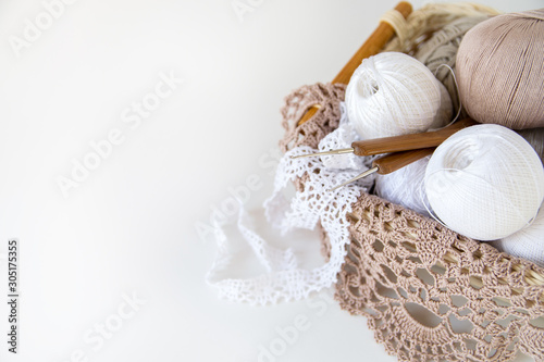 White lace, hand knitting yarn, crochet hook. Copy space.