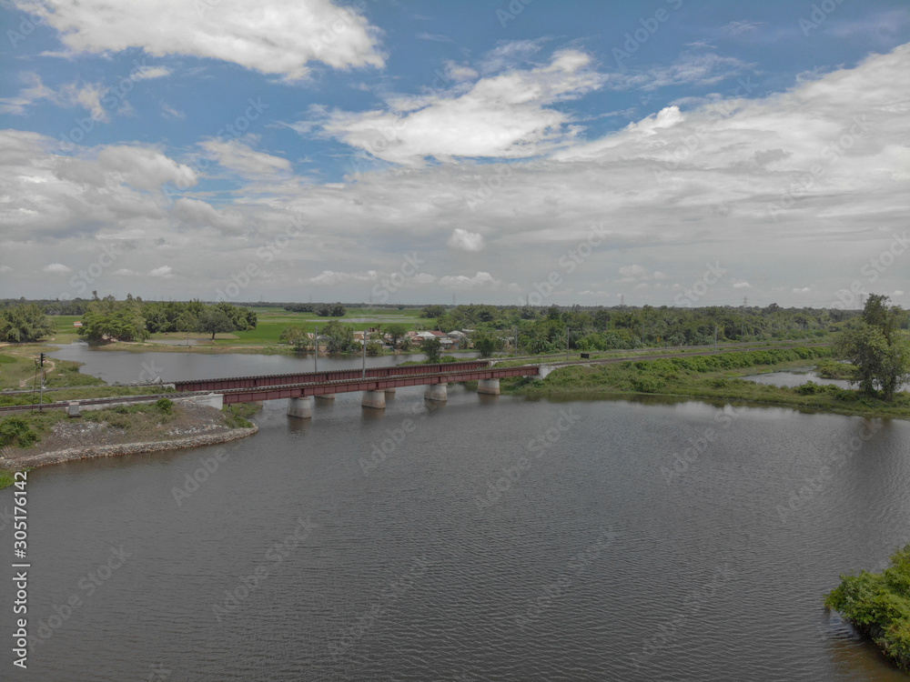partially cloudy day , flowing river water with the rail bridge which adds to the beauty of the picture. partially cloudy day , flowing river water with the rail bridge which adds to the beauty of the picture.