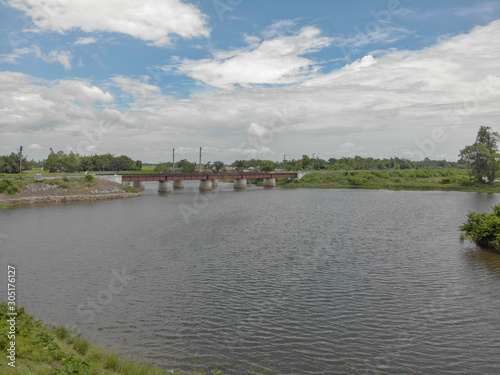 partially cloudy day , flowing river water with the rail bridge which adds to the beauty of the picture.