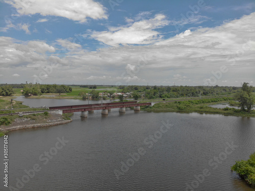 partially cloudy day , flowing river water with the rail bridge which adds to the beauty of the picture.