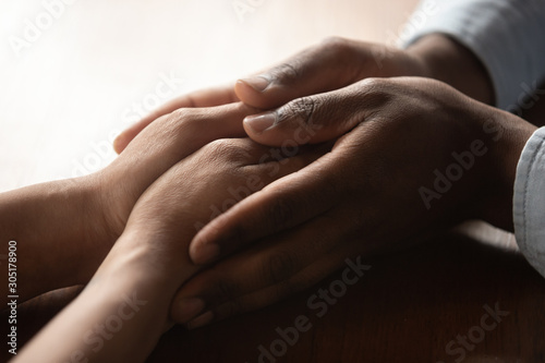 African American couple hold hands enjoying tenderness