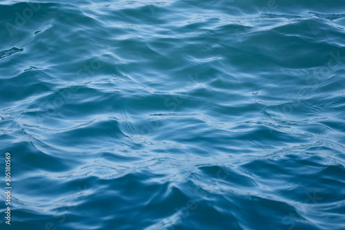 Blurry natural blue background. The texture of the water of the sea. Ripples of the blue surface of the water.Horizontal, cropped shot, close-up. The concept of nature and tourism. © Nataliia
