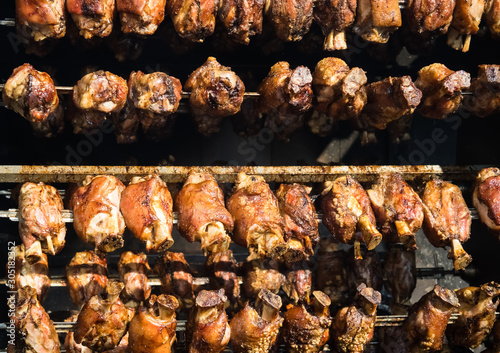 Street food, grilled meat, pork roasting on skewers, meat preparation outdoors - Image