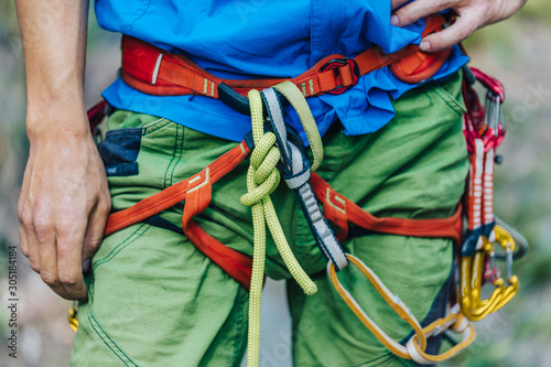 Close up detail of a man wearing climbing harness. Outdoor climbing equipment.