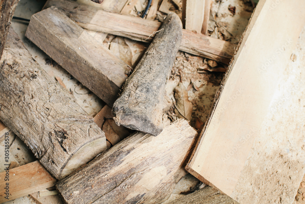 Cut timber into pieces to making firewood,timbers wood Pile of timber wood used for scaffolding and structure in house building construction