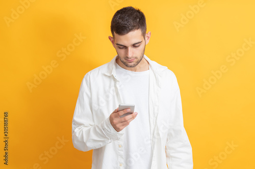 portrait of young man with mobile phone on color background