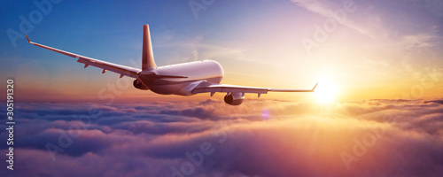 Passengers commercial airplane flying above clouds photo