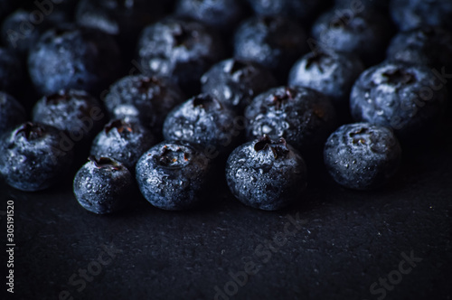 Blueberries close up macro on a black slate background.