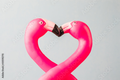 Two pink flamingo toys form a heart