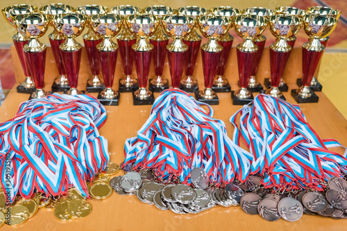 medals and cups. many medals to be awarded. cups close up. olympiad rewarding. prizes at the competition. photo