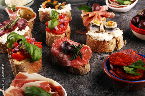 Appetizers table with italian antipasti snacks and wine in glasses. Brushetta or authentic traditional spanish tapas set, cheese variety