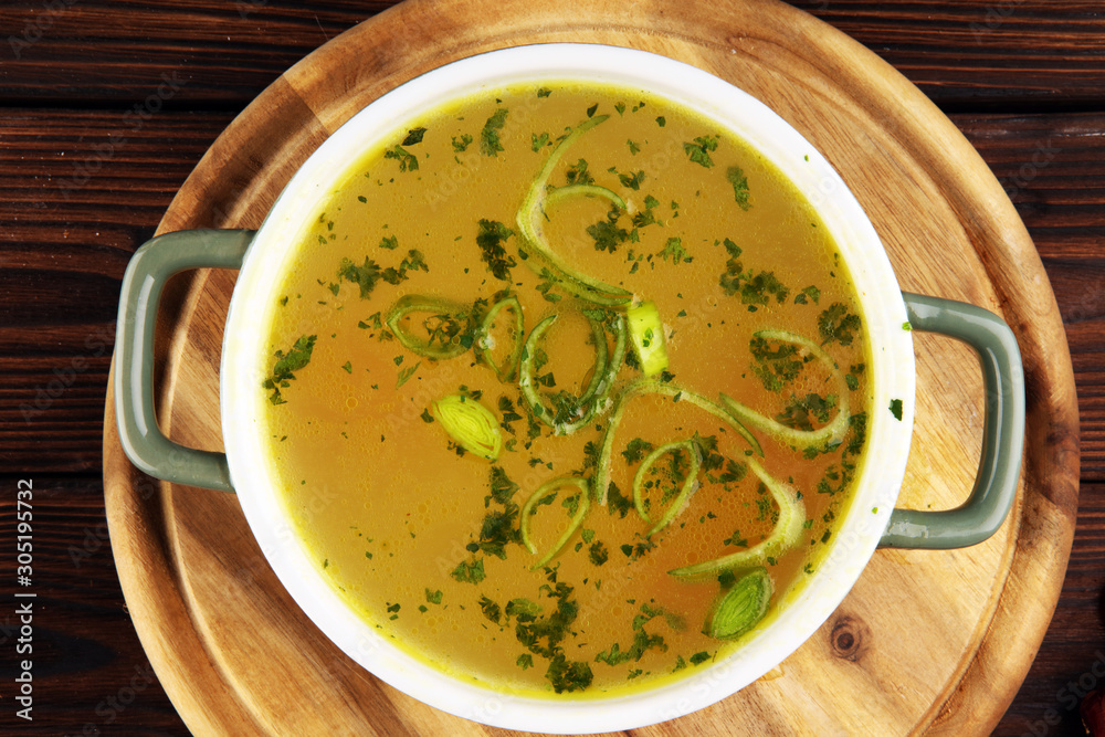 Broth with carrots, onions various fresh vegetables in a pot - colorful fresh clear spring soup. Rural kitchen scenery vegetarian bouillon stock Broth with carrots, onions various fresh vegetables in a pot - colorful fresh clear spring soup. Rural kitchen scenery vegetarian bouillon stock