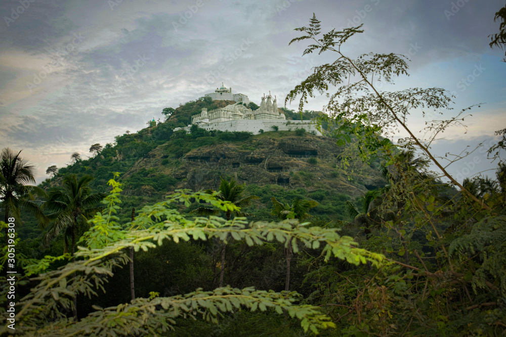 A white colored temple on a green mountain
