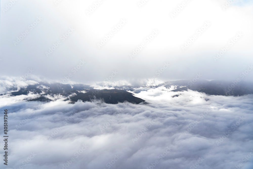 views of the mountains, clouds and fog below during a hot air balloon flight in La Cerdanya, Catalonia