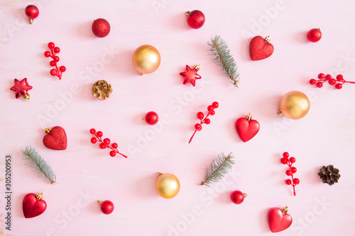 Pink wooden christmas background with red and gold color christmas decorations. View from above