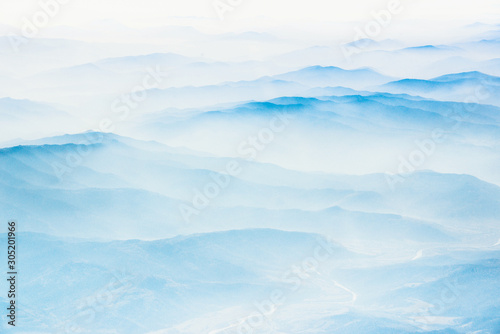 Aerial view of distant mountains layers range in morning mist. Meditation and zen landscape. © vovik_mar