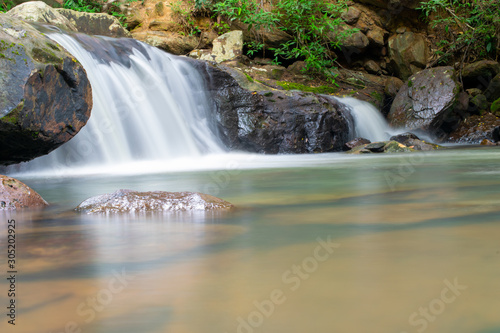 little stone water fall on green tree background