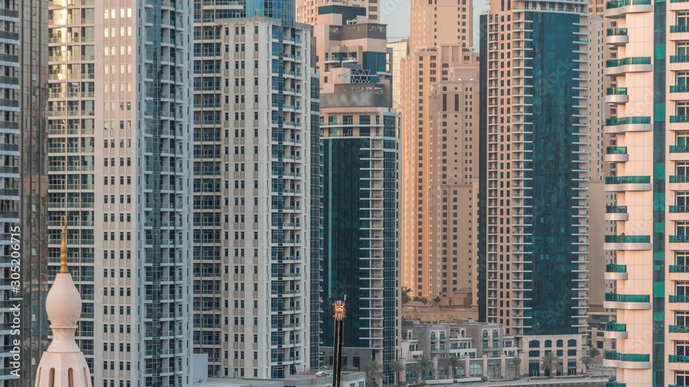 Obraz premium Luxury yachts parked on the pier in Dubai Marina bay with city aerial view timelapse