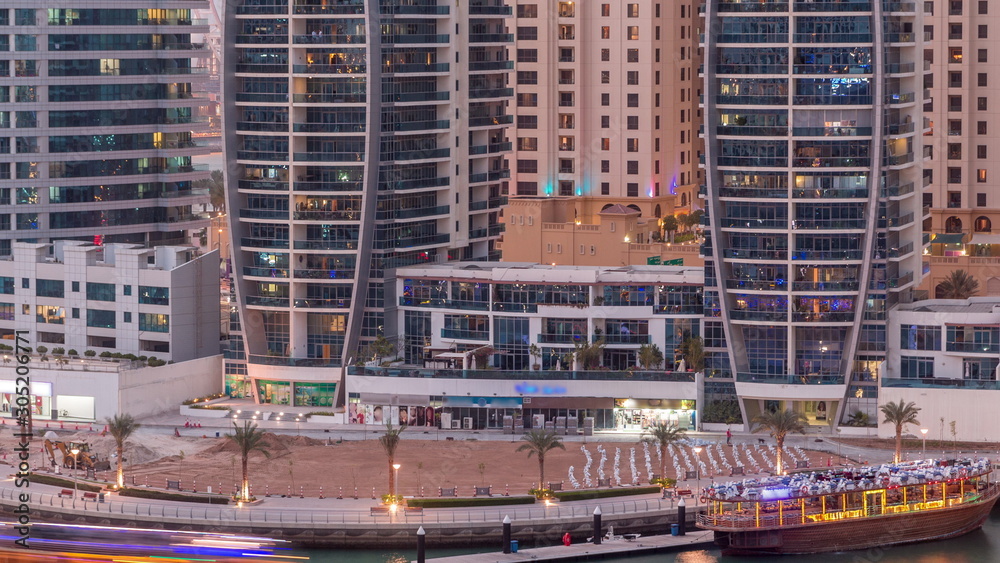Dubai Marina skyscrapers, port with luxury yachts and Marina promenade aerial day to night timelapse, Dubai, United Arab Emirates