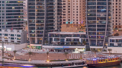 Dubai Marina skyscrapers, port with luxury yachts and Marina promenade aerial day to night timelapse, Dubai, United Arab Emirates