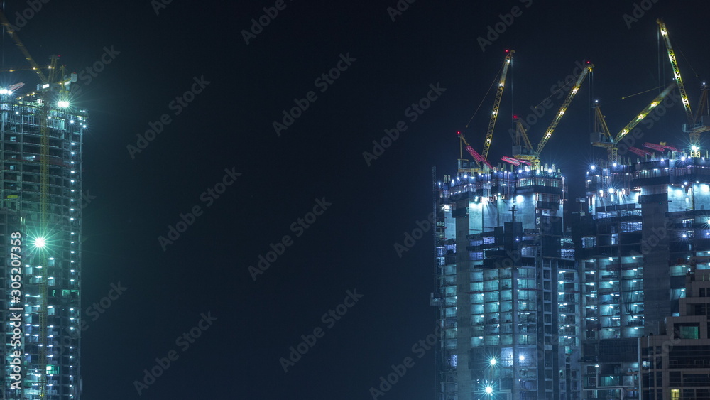 Aerial view of a skyscraper under construction with huge cranes timelapse in Dubai marina. Aerial view of a skyscraper under construction with huge cranes timelapse in Dubai marina.