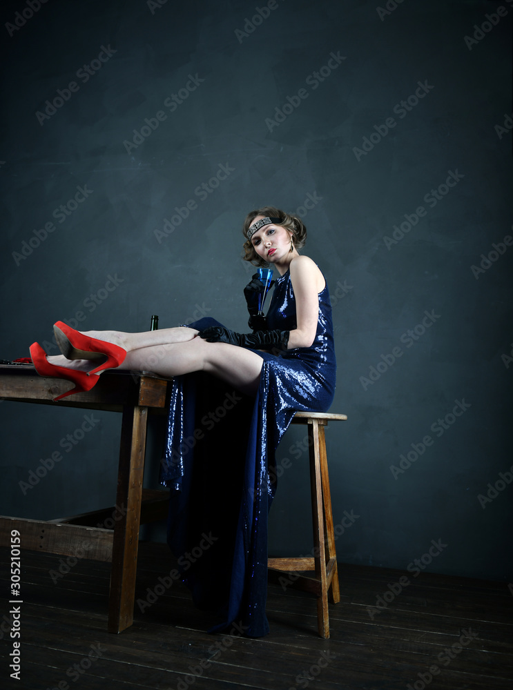 girl in a blue evening dress with a blue glass
