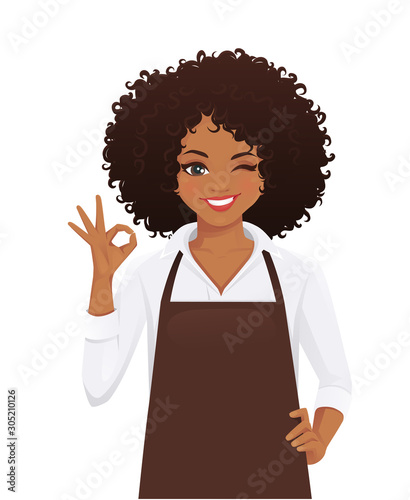 Smiling woman in apron with afro hairstyle gesturing ok sign isolated vector illustration