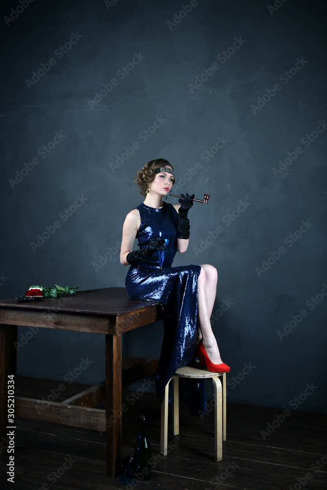 girl in a blue evening dress with a pipe