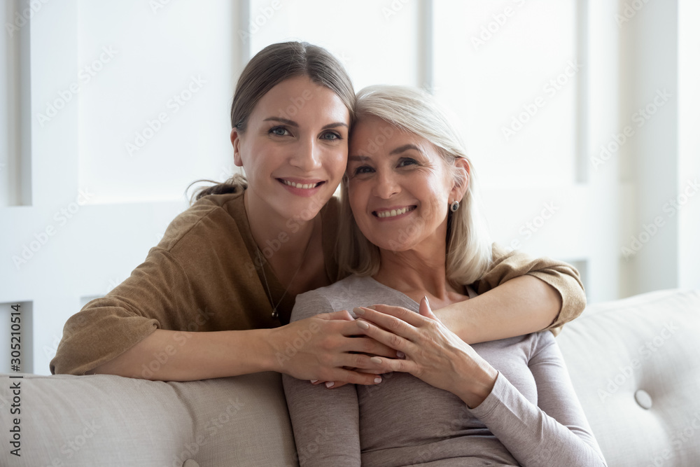 Head shot smiling young woman embracing middle aged mother. Head shot smiling young woman embracing middle aged mother.