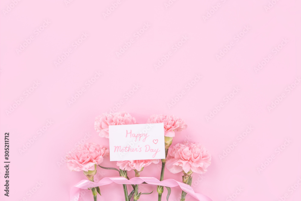 Beautiful, fresh elegant carnation flower bouquet with white greeting thanks gift card isolated on bright pink color background, top view, flat lay concept.