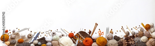 Panoramic view of composition with knitting accessories: balls of wool yarn, knitting needles, hooks, scissors and other knit tools on white background. Long banner, top view, copy space, flat lay photo