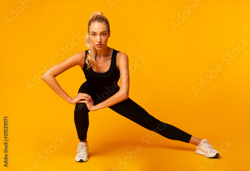 Girl Doing Side Lunge Stretching Legs, Studio Shot