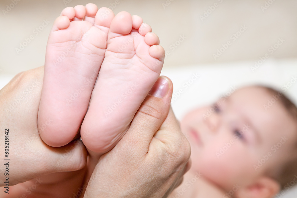 Baby feet in mother hands, close up view Baby feet in mother hands, close up view