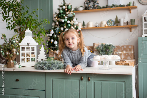 Little girl in kitchen at Christmas home.