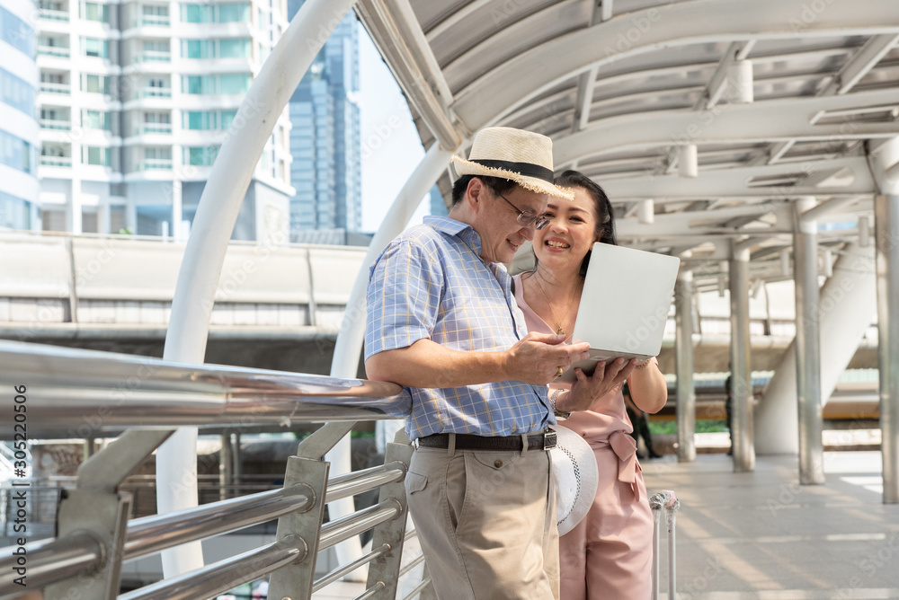 Couple Using Laptop While Standing On Bridge In City