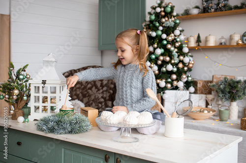 Girl is sitting on kitchen table at Christmas home