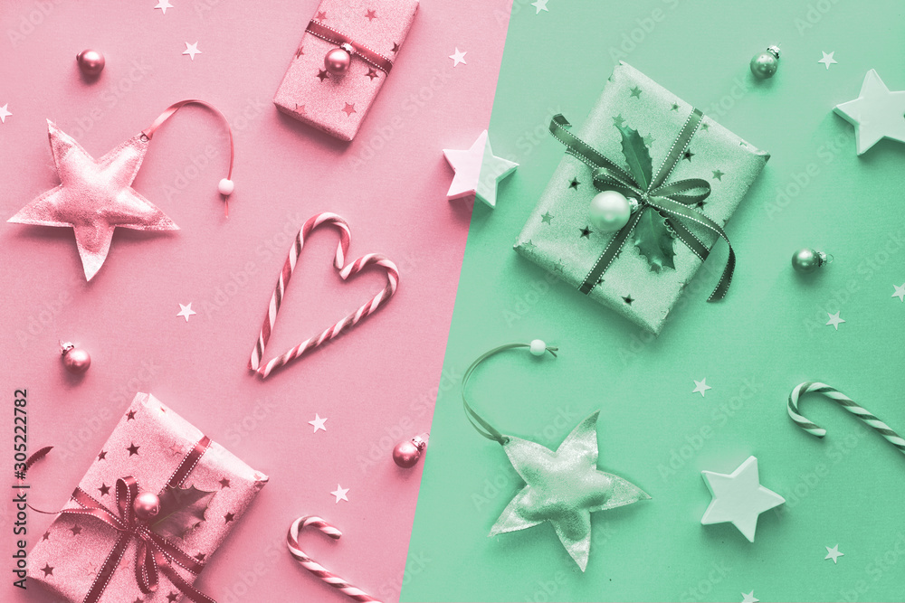 Monochrome split two tone Xmas background in pink and trendy neo mint green colors. Gift boxes, stripy candy canes, trinkets and stars arranged in Christmas geometric pattern. Monochrome split two tone Xmas background in pink and trendy neo mint green colors. Gift boxes, stripy candy canes, trinkets and stars arranged in Christmas geometric pattern.