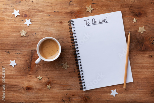 Photography Coffee cup, stars confetti and notebook with to do list on wooden desk top view, planning and design concept