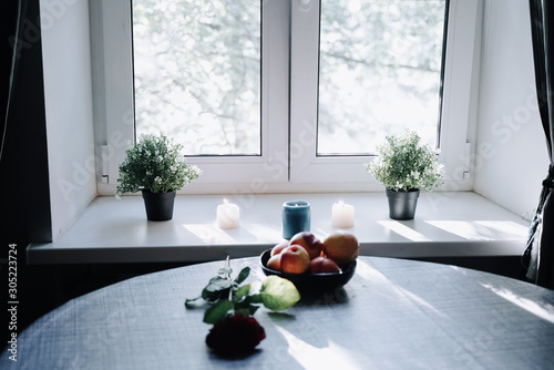 a plate of peaches on the table in front of the white windowsill photo