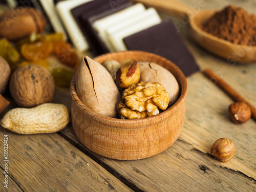 Nuts in a wooden Cup on a wooden table and other sweets