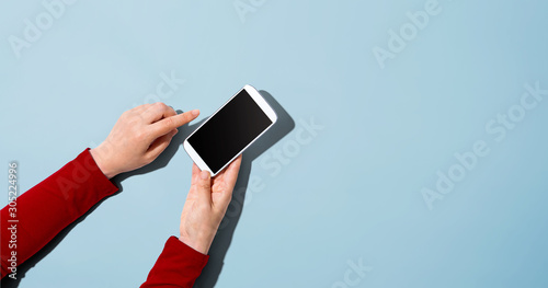 Person using a white smartphone - overhead view photo