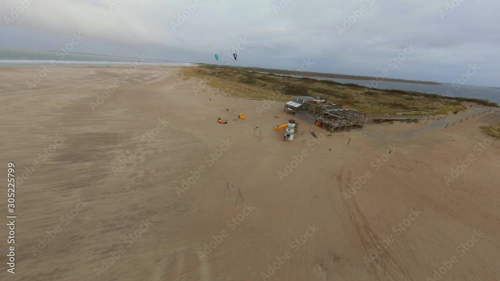 Kitesurfers preparing to go the water next to a beach club. Aerial shot. Kitesurfers preparing to go the water next to a beach club. Aerial shot.
