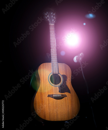 Acoustic wooden a guitar over black background.