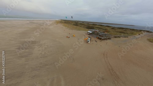 Kitesurfers preparing to go the water next to a beach club. Aerial shot. photo