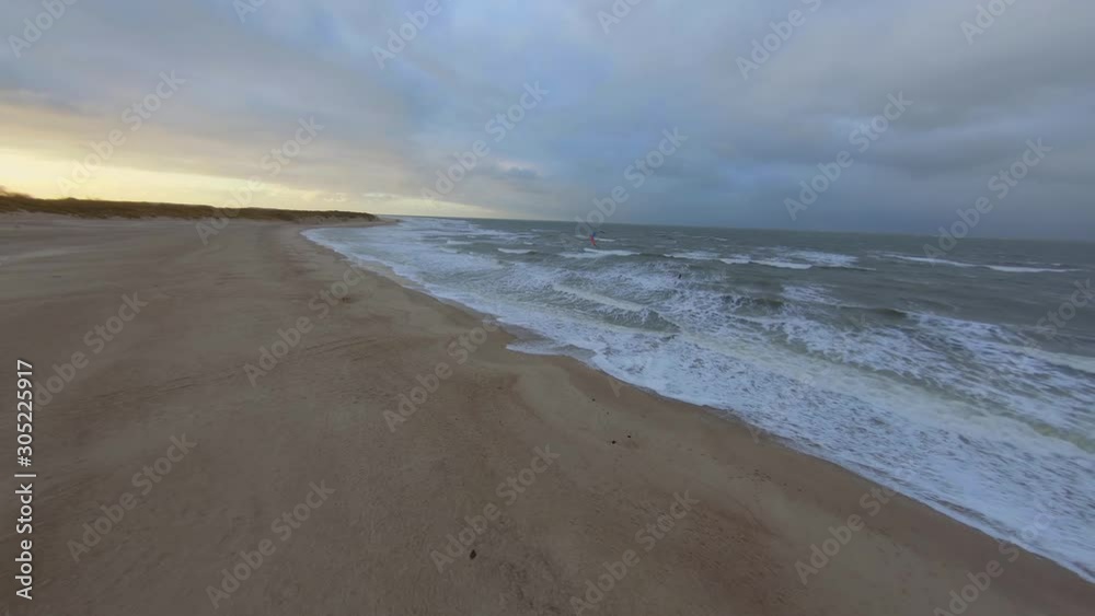 Follow shot of a kitesurfer during a cold day in autumn. Aerial shot in the Netherlands. Follow shot of a kitesurfer during a cold day in autumn. Aerial shot in the Netherlands.